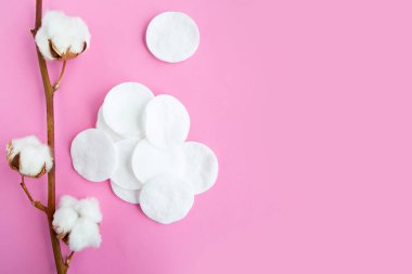 Pembe pastel arka planda pamuk ve pamuk süngerleri, üst görünüm, boşluk kopyala