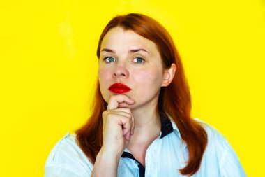 Sarı arka planda düşünceli kızıl saçlı kızın portresi.