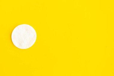 Parlak sarı arkaplanda pamuk süngeri, üst görünüm, kopyalama alanı