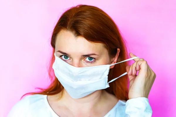 Woman puts on medical face mask, closeup
