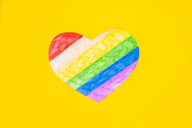 Parlak sarı arkaplanda lgbtq renginde kalp, üst görünüm