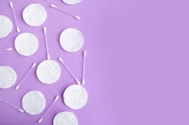 Mor arkaplan üzerindeki pamuk süngerler ve pamuk tomurcukları deseni, minimal konsept, kopyalama alanı