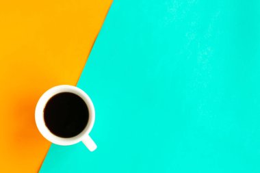 Geometrik turuncu ve yeşil arkaplan üzerine kahve fincanı, üst görünüm, metin için kopya alanı, asgari konsept