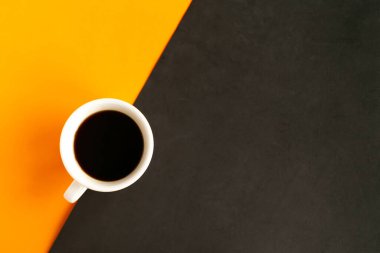 Geometrik turuncu ve siyah arkaplan üzerine kahve fincanı, üst görünüm, metin için kopyalama alanı, asgari konsept