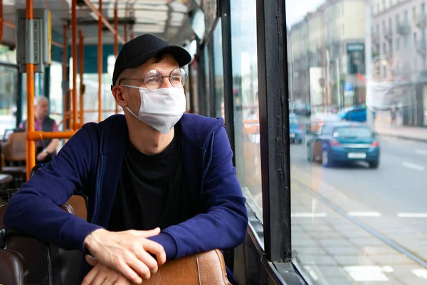 Otobüste koruyucu maskeli bir adam var. Coronavirus covid-19 salgını sırasında toplu taşıma