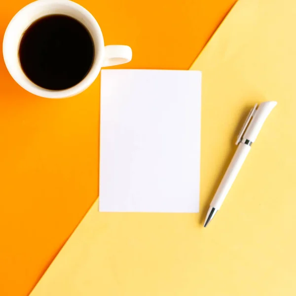 幾何学的な黄色とオレンジの背景にコーヒーカップと白のモックアップブランク トップビュー ミニマルなコンセプト — ストック写真