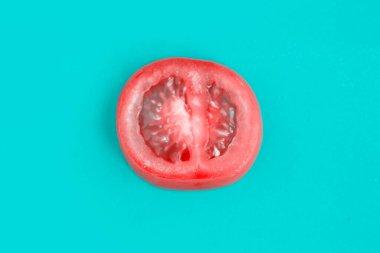 Mavi arka planda izole edilmiş taze domates kaydır, minimalizm kavramı
