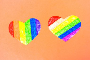 Pembe arka planda lgbtq sütunlarında iki kalp, üst görünüm