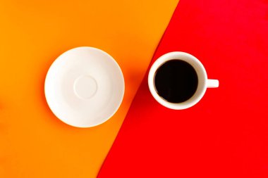 Boş tabak ve kahve fincanı geometrik turuncu ve kırmızı arka plan, üst manzara. Asgari konsept