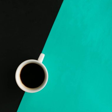 Geometrik siyah ve yeşil arkaplan üzerine kahve fincanı, üst görünüm, metin için kopyalama alanı, asgari konsept
