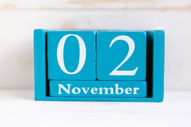 2 Kasım. Ahşap zemin üzerinde ay ve tarih olan mavi küp takvimi.