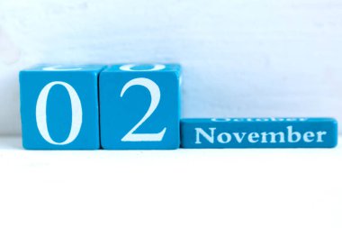 2 Kasım. Ahşap zemin üzerinde ay ve tarih olan mavi küp takvimi.