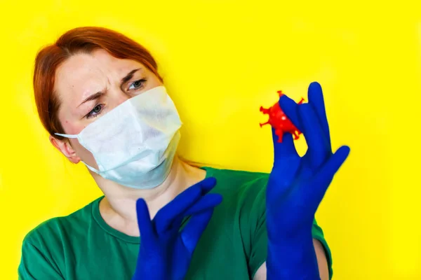 医療用マスクの女の子は手に赤い細菌を持っていますCovid 19の概念 — ストック写真