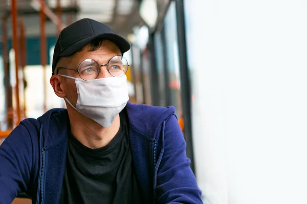 Otobüste koruyucu maskeli bir adam var. Coronavirus covid-19 salgını sırasında toplu taşıma