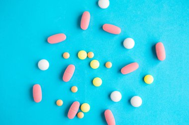 Parlak mavi arka planda tıbbi haplar, covid-19 konsepti