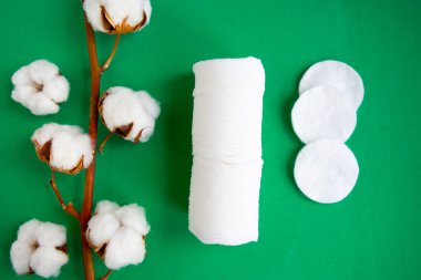 Koyu yeşil arka planda pamuk ve pamuk süngerleri, üst görünüm