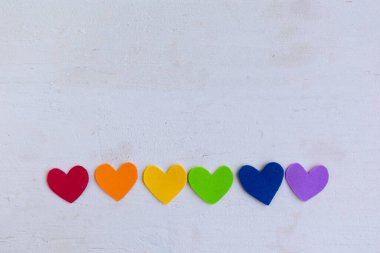Ahşap arkaplan üzerinde lgbtq renginde kalpler, üst görünüm, boşluk kopyala
