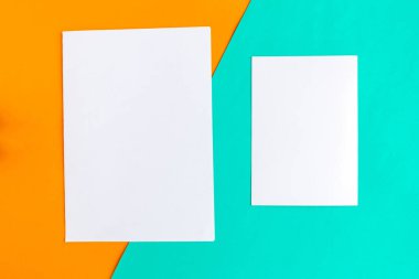 Geometrik turuncu ve turkuaz arka planda iki beyaz model boş. Metin için alanı kopyala. 