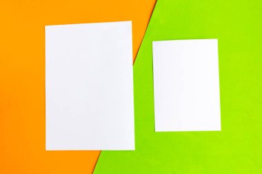 Geometrik turuncu ve yeşil arka planda iki beyaz model boş. Metin için alanı kopyala. 