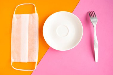 Tıbbi maske ve arka planda boş bir plaka. Minimum konsept. Covid-19 konsepti