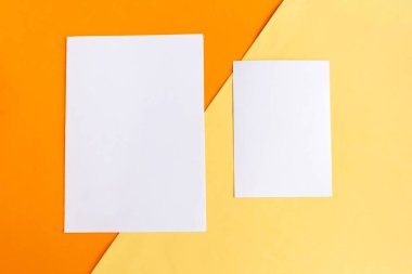 Geometrik turuncu ve sarı arka planda iki beyaz model boş. Metin için alanı kopyala. 