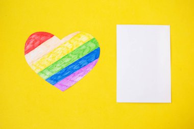 lgbtq renklerinde kalp ve sarı arkaplan üzerinde beyaz model, üst görünüm, boşluk kopyala