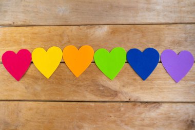 Ahşap arka planda lgbtq renginde kalpler, üst görünüm