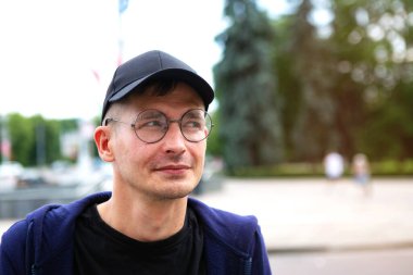 Şehir manzarasının arka planında genç bir adamın portresi, yakın plan.