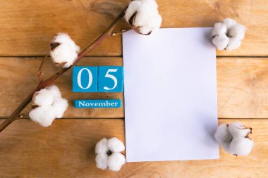 5 Kasım. Ahşap zemin üzerinde ay ve tarih olan mavi küp takvimi.