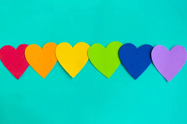 Yeşil arkaplandaki lgbtq renklerindeki kalpler, üst görünüm, boşluk kopyala