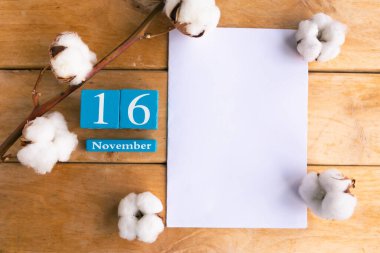 16 Kasım. Ahşap zemin üzerinde ay ve tarih olan mavi küp takvimi.