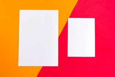 Geometrik turuncu ve kırmızı arka planda iki beyaz model boş. Metin için alanı kopyala. 
