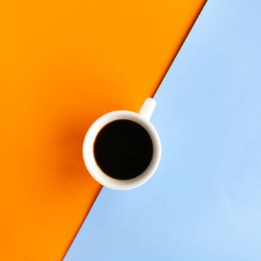 Geometrik turuncu ve mavi arkaplan üzerine kahve fincanı, üst görünüm, metin için kopyalama alanı, asgari konsept