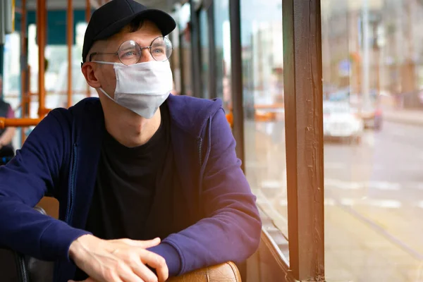 Otobüste koruyucu maskeli bir adam var. Coronavirus covid-19 salgını sırasında toplu taşıma