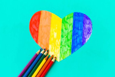 Yeşil naneli arka planda lgbtq renklerinde kalp ve kalemler, üst görünüm