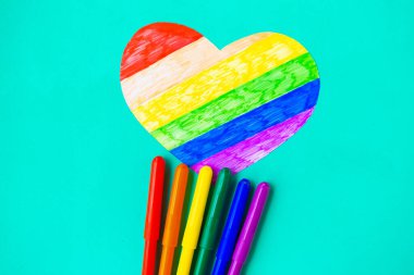 Yeşil naneli arka planda lgbtq renklerinde kalp ve kalemler, üst görünüm