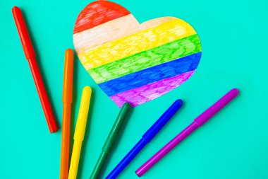 Yeşil naneli arka planda lgbtq renklerinde kalp ve kalemler, üst görünüm