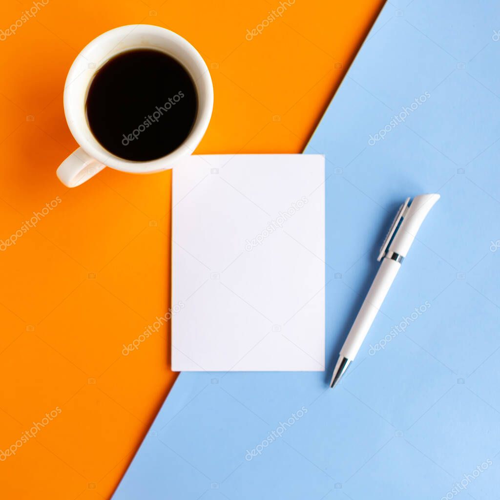Coffee cup and white mockup blank on geometric blue and orange background, top view. Minimal concept