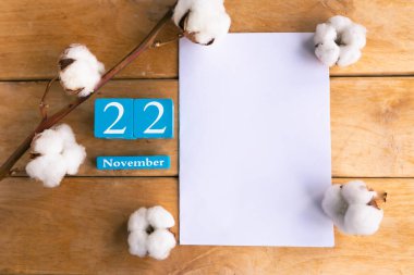 22 Kasım. Ahşap zemin üzerinde ay ve tarih olan mavi küp takvimi.