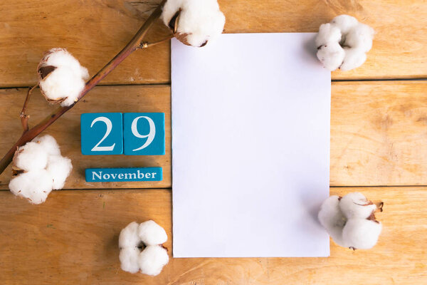 November 29. Blue cube calendar with month and date on wooden background.