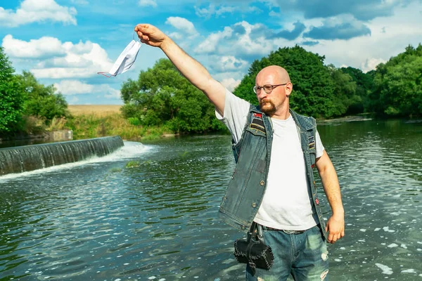 Man throws away medical mask. Coronavirus free concept