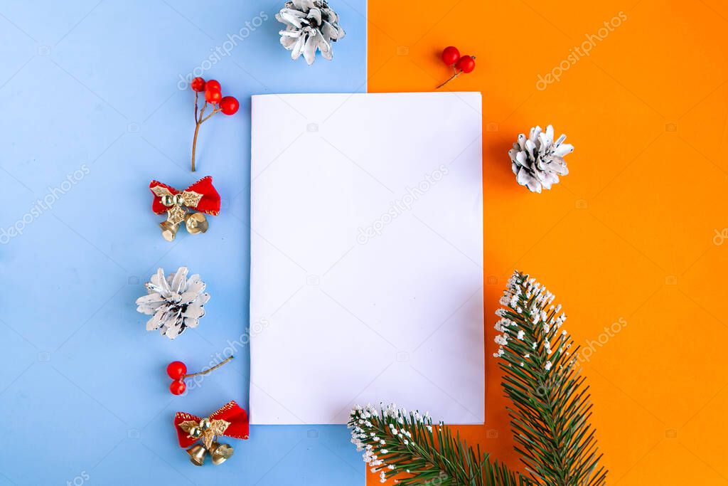 White mockup blank and Christmas decorations on color background. Copy space for the text. Template for Christmas greeting card. Merry Christmas and Happy New Year
