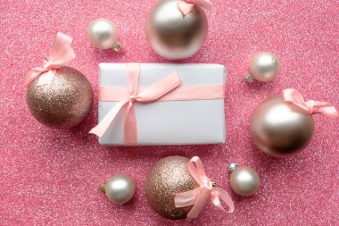 Noel mücevherleri ve pembe arkaplanlı hediye kutusu, metin için kopyalama alanı. Mutlu Noeller tebrik kartı.