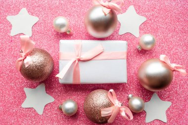 Noel mücevherleri ve pembe arkaplanlı hediye kutusu, metin için kopyalama alanı. Mutlu Noeller tebrik kartı.