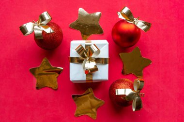 Kırmızı arka planda altın Noel süslemeleri. Mutlu Noeller ve mutlu yıllar.