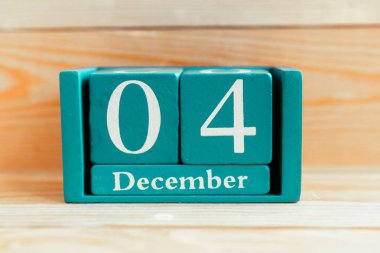 4 Aralık. Ahşap zemin üzerinde ay ve tarih olan mavi küp takvimi.