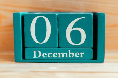 6 Aralık. Ahşap zemin üzerinde ay ve tarih olan mavi küp takvimi.
