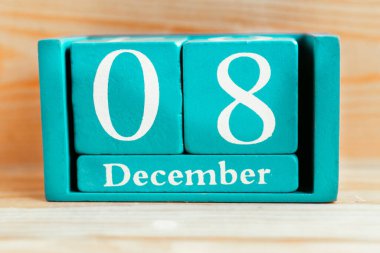 8 Aralık. Ahşap zemin üzerinde ay ve tarih olan mavi küp takvimi.