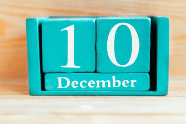 10 Aralık. Ahşap zemin üzerinde ay ve tarih olan mavi küp takvimi