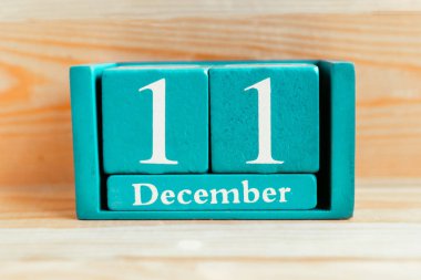 11 Aralık. Ahşap zemin üzerinde ay ve tarih olan mavi küp takvimi.
